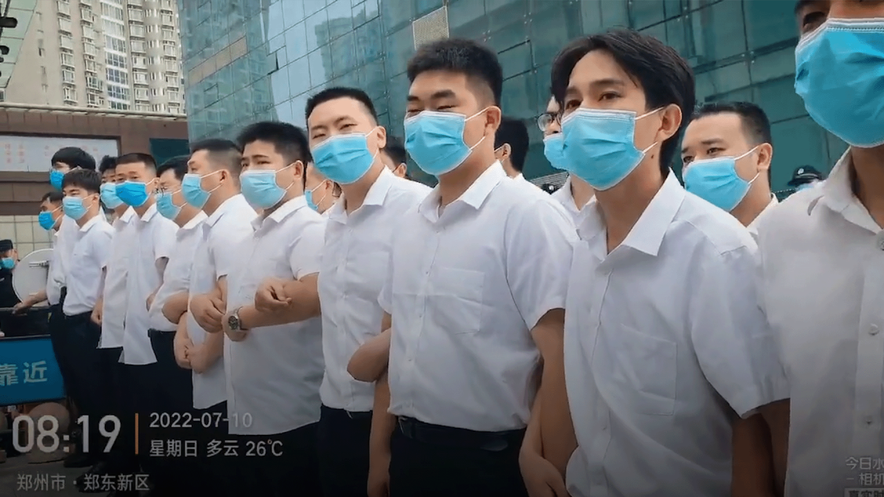 Victims of one of China’s worst financial scandals attacked by unidentified men in white at protest